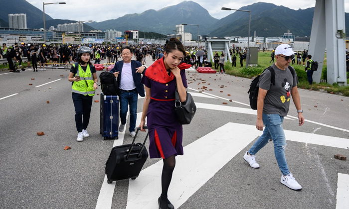 ฮ่องกงประท้วง: กลุ่มผู้ชุมนุมบุกสนามบินอีกครั้ง รถไฟด่วนหยุดบริการชั่วคราว