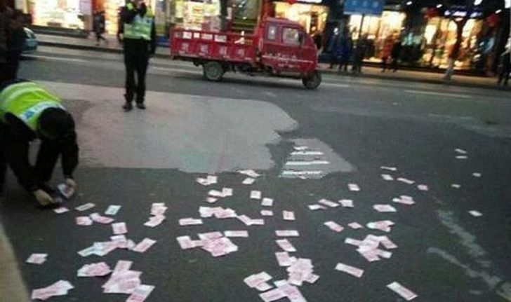 หญิงชาวจีนโปรยเงินทิ้งกลางถนน เดือดร้อนตำรวจช่วยเก็บ