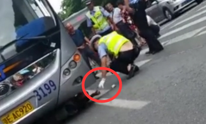 ชายจีนมุดใต้ท้องรถเมล์แกล้งถูกชน ตำรวจโยนเงินล่อออกมา