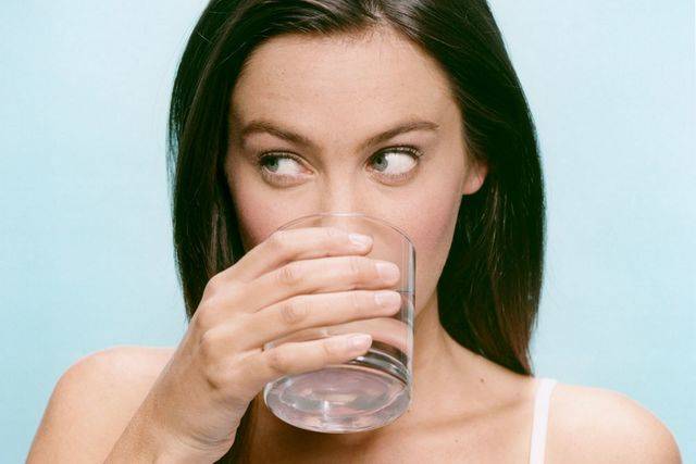 1449031049 woman drinking glass of water 873302