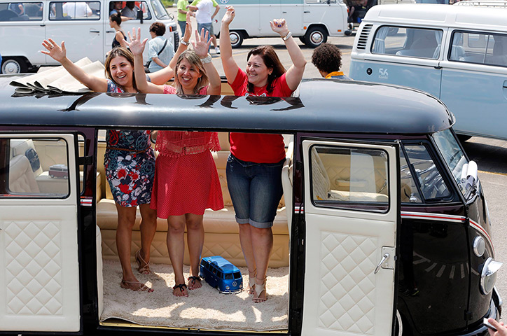 Visitors cheer inside a Volkswagen Kombi minibus