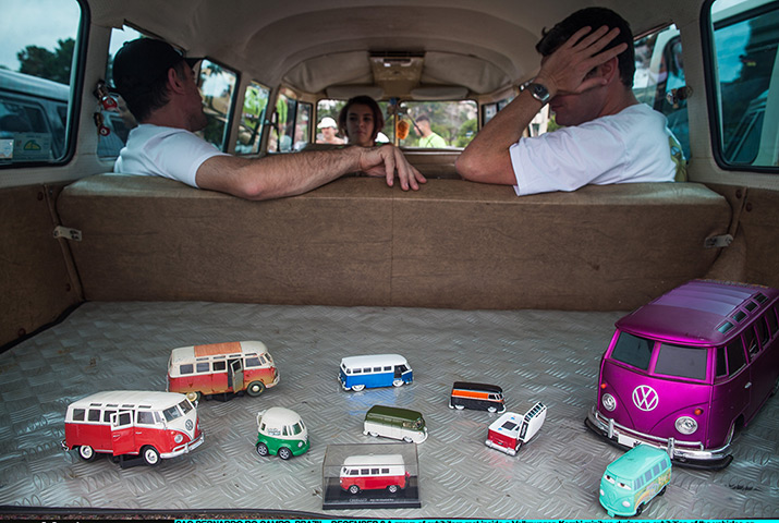 Exhibitors rest inside a Volkswagen Kombi minibus with toy models