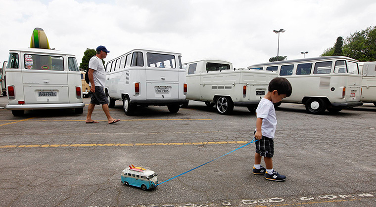 A boy pulls along his Volkswagen Kombi toy