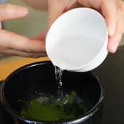 2. ตักผงที่กรองแล้วใส่ถ้วยและตีให้ละลายกับน้ำร้อนด้วยแปรงชงชาเขียว