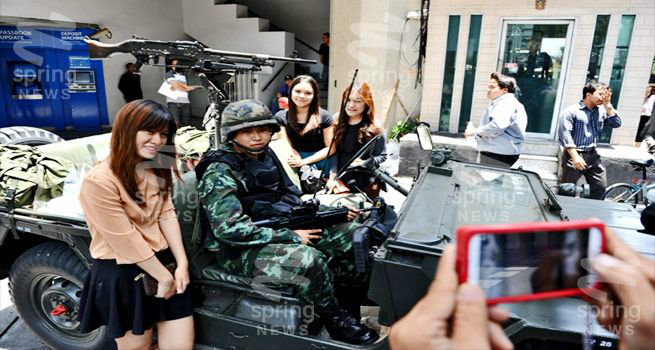 สื่อนอกเผย คนไทยไม่เครียด แห่ถ่ายรูปกับทหาร