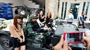 สื่อนอกเผย คนไทยไม่เครียด แห่ถ่ายรูปกับทหาร