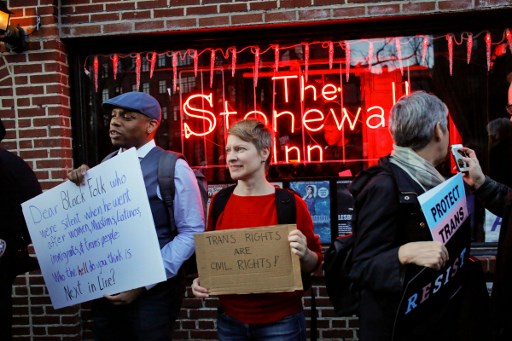 ผู้คนมารวมตัวกันด้านหน้า Stonewall Inn สถานที่สำคัญทางประวัติศาสตร์ของชาว LGBTQ+ ที่อเมริกา เมื่อวันที่ 23 มกราคม 2017 เพื่อเรียกร้องให้มีการคุ้มครองสิทธิ์ของคนข้ามเพศและคนที่มีความลื่นไหลทางเพศ