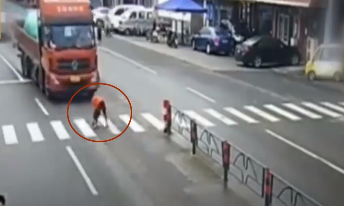 หญิงจีนช่วยสุนัขเป็นลมกลางถนน สุดท้ายถูกรถบรรทุกชนกระเด็น (มีคลิป)