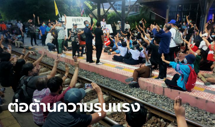 คณะราษฎรอยุธยา ชู 3 นิ้ว นั่งเคารพธงชาติบนสถานีรถไฟ หลังนักเรียนถูกป้าตบเพราะไม่ยืน