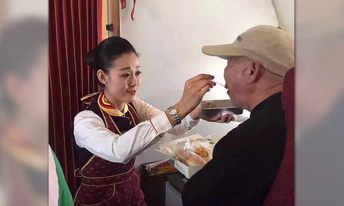 เมืองจีนแชร์สนั่น แอร์โฮสเตสสาวป้อนข้าวผู้โดยสารพิการ