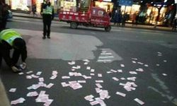หญิงชาวจีนโปรยเงินทิ้งกลางถนน เดือดร้อนตำรวจช่วยเก็บ