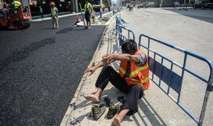 ชีวิตต้องสู้! ภาพคนงานสร้างถนนในจีน ร้อนจัดจนเท้าพอง