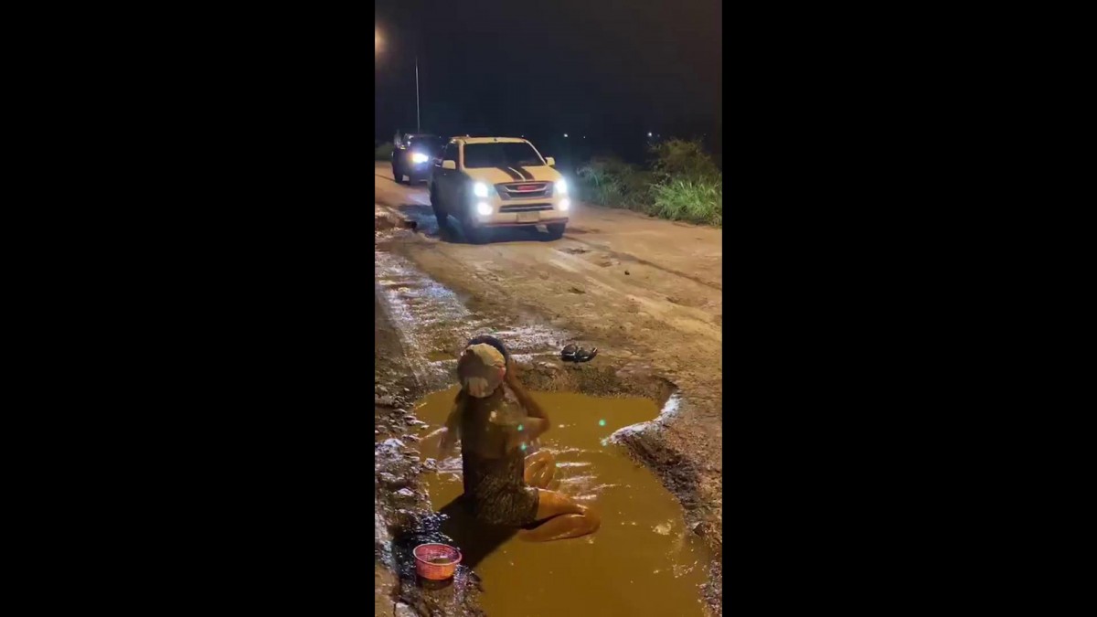 โชเซียลแห่แชร์ หนุ่มนุ่งกระโจมอกอาบน้ำกลางถนนหลุมลึก วอนหน่วยงานช่วยซ่อมถนน