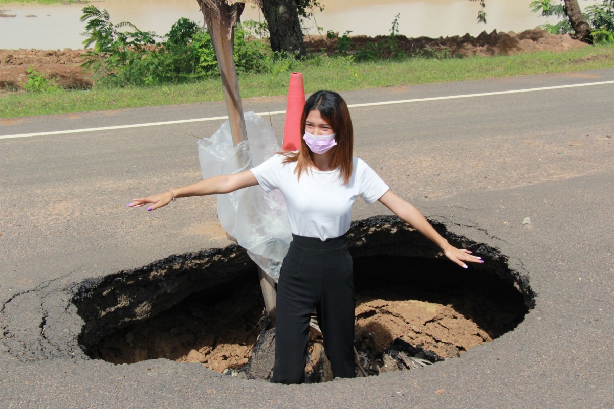 ถนนทรุดเป็นหลุมยักษ์สุดอันตราย ผ่านมานานยังไม่ซ่อม ชาวบ้านลงหลุมเซลฟี่ประชด