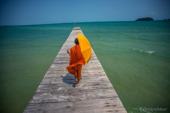 A monk walking down a pier