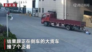 หนุ่มจีนเดินเล่นมือถือ ถูกรถบรรทุกถอยหลังชนล้มตีลังกา หวิดโดนเหยียบซ้ำ