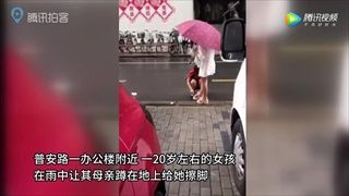 วิจารณ์สนั่น สาวจีนใช้แม่นั่งเช็ดเท้าให้กลางสายฝน แถมทิ้งทิชชูไว้ริมถนน