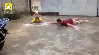 สองชายสุดดีใจ นอนว่ายน้ำท่ากบกับพื้น หลังฝนตกช่วยคลายร้อนในยูนนาน
