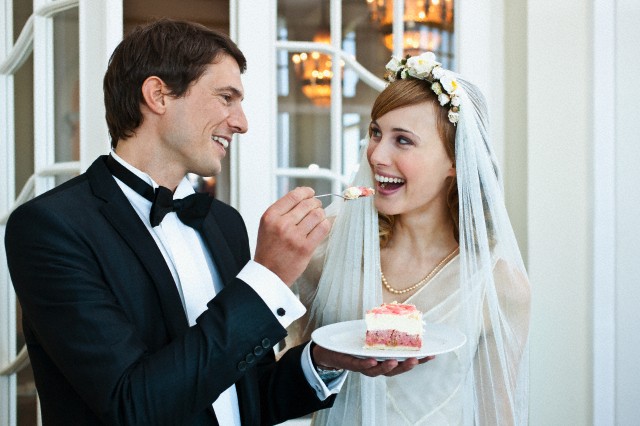 Newlyweds eating wedding cake