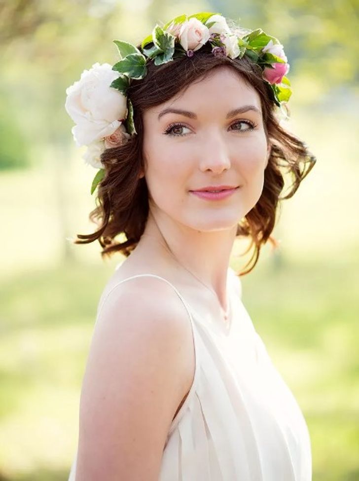 Short curly wedding hairstyle with an ivy and rose flower crown