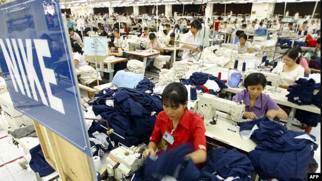 Vietnamese workers work at a sportswear production line for Nike at the Nha Be garment company in Ho Chi Minh City