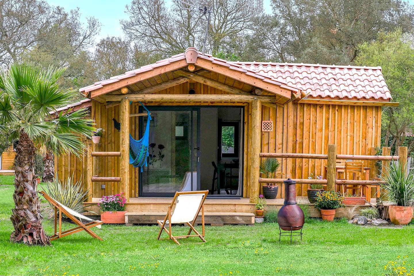 บ้านไม้หลังเล็กน่ารัก บรรยากาศอบอุ่น ล้อมรอบด้วยสนามหญ้าและต้นไม้